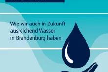 Zu sehen ist das erste Plakat der Wasserausstellung mit dem Titel und einer Hand, die einen großen Wassertropfen fängt.